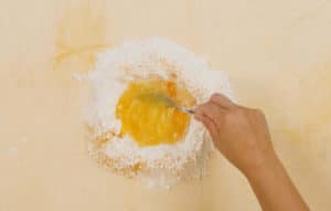 Mescolare la curcuma con il sale, la farina e l'uovo