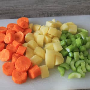 Tagliare a pezzettoni il sedano, le patate e le carote